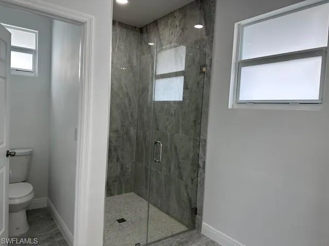 Bathroom featuring an enclosed shower and toilet
