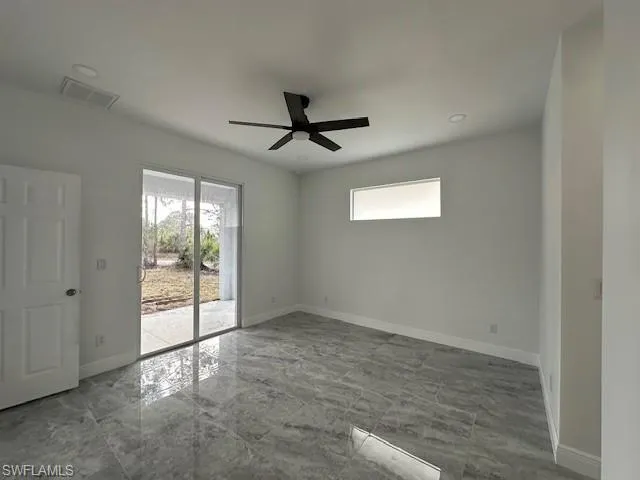 Empty room with ceiling fan and a wealth of natural light