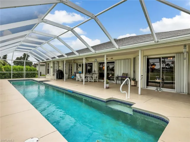Screened-in swimming pool featuring a rectangular design with integrated steps and a pool deck
