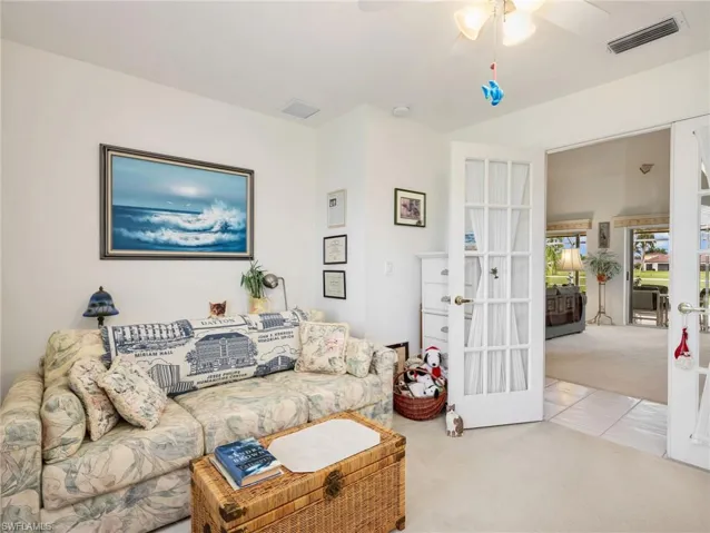 Interior room with white walls, carpet flooring, a ceiling fan, and French doors