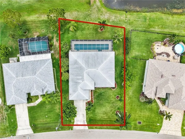 Aerial perspective of the property featuring a rectangular pool within a screened enclosure