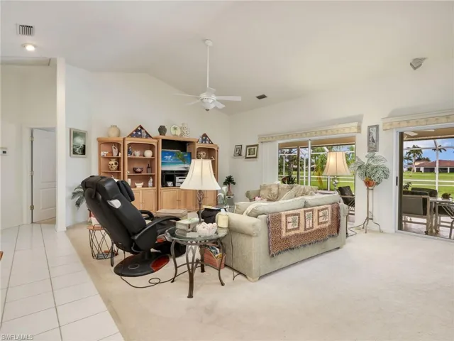 Spacious living area featuring vaulted ceilings, recessed lighting, and a ceiling fan