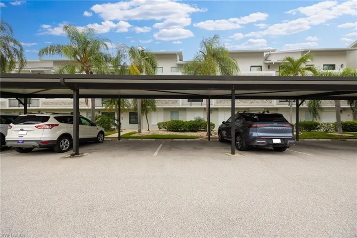 Covered parking structure featuring multiple bays, a dark metal frame, and a paved surface