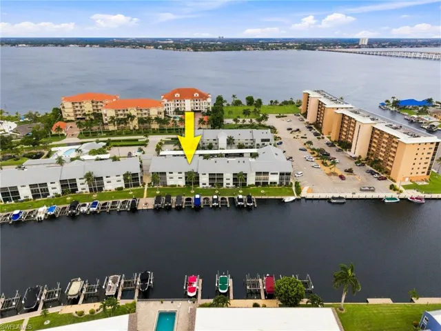 Waterfront condominium complex featuring private boat slips, direct water access, and a community swimming pool
