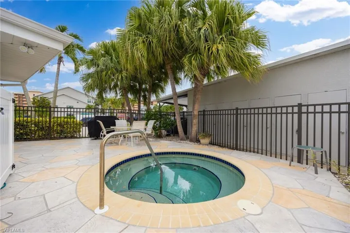 Outdoor spa with integrated steps and a stainless steel grab rail