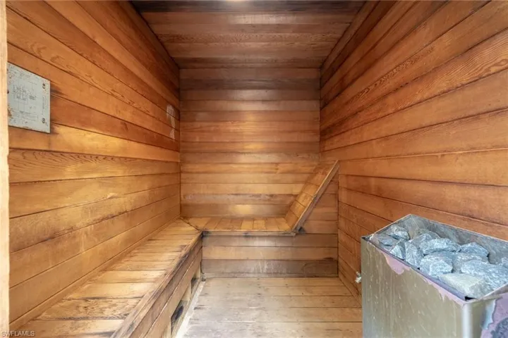 Dedicated sauna room featuring wood-paneled walls and ceiling