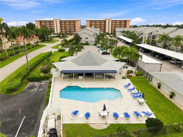 Resort-style pool area featuring a large swimming pool, spacious pool deck, and a shaded cabana structure