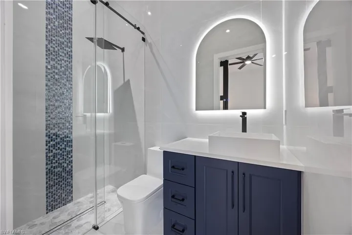 Mother in law Full bathroom featuring tile walls, a stall shower, and vanity