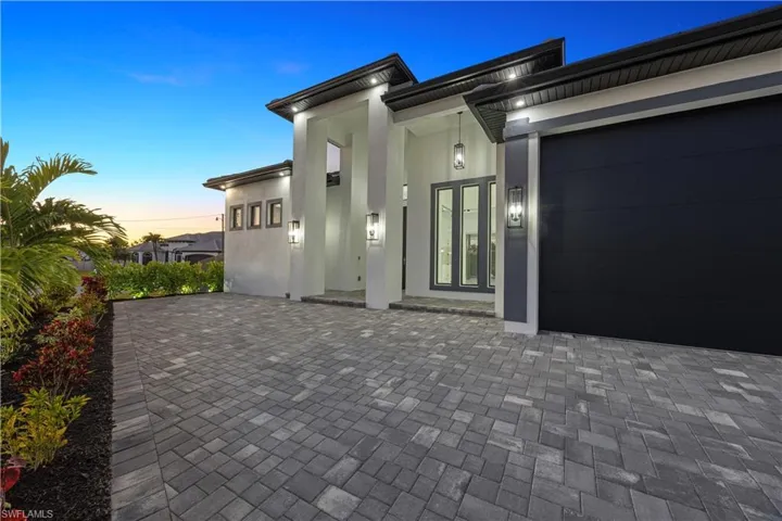 Entrance to property with an attached garage and stucco siding