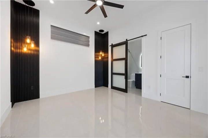 Mother in Law bedroom featuring a barn door, ensuite bath, ceiling fan, and recessed lighting