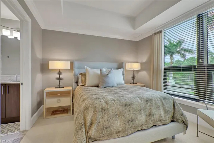 Bedroom featuring ornamental molding, a tray ceiling, and carpet flooring