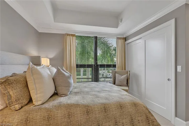 Bedroom featuring a closet, a raised ceiling, carpet, and ornamental molding