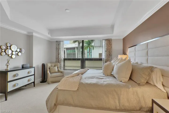 Bedroom with carpet floors, crown molding, and a tray ceiling