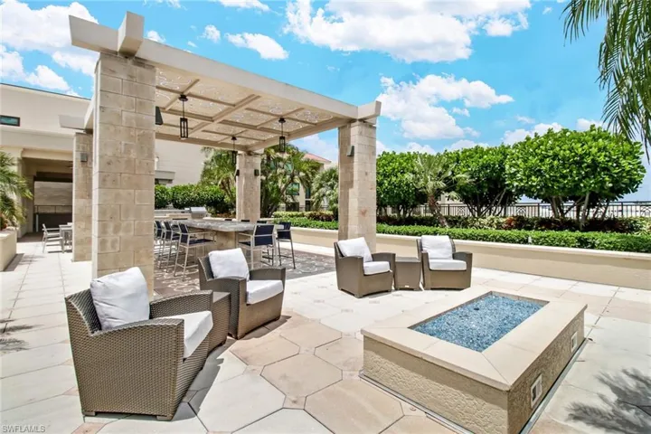 View of patio featuring a fire pit, an outdoor lounge area with bar, and a pergola