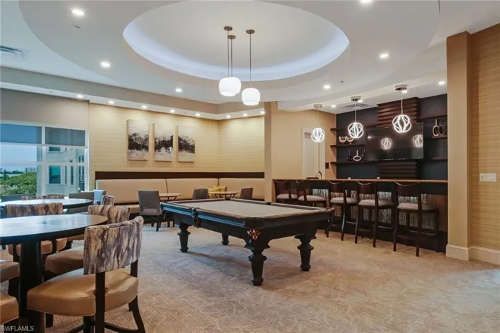 Rec room featuring pool table, a tray ceiling, recessed lighting, and bar with sink