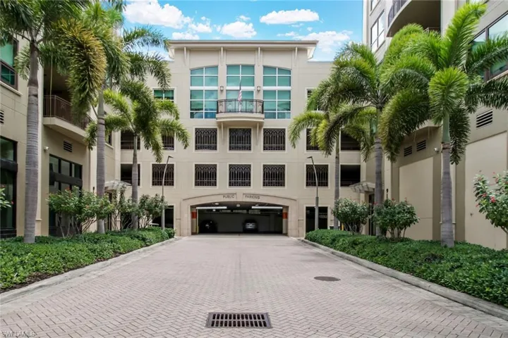 View of building exterior with decorative driveway and an attached garage
