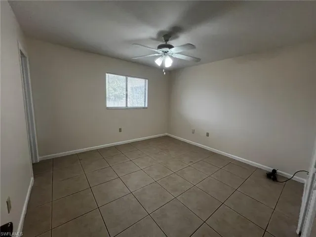 The Master bedroom with lighted ceiling fan and large tile.