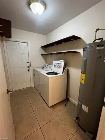 Interior Laundry room with full sized Washer and Dryer, provided for tenant convenience. Extra shelving for storage. Exterior door to patio.
