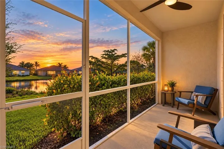Screened lanai featuring a concrete floor, ceiling fan, and metal-framed screening, overlooking a pond and landscape backdrop