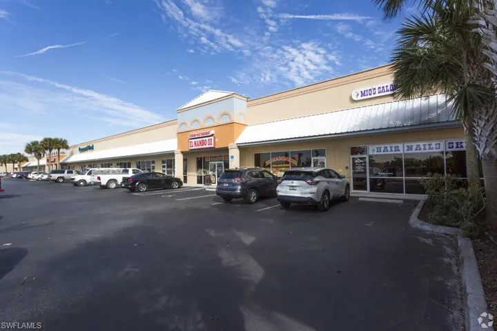 View of building exterior featuring uncovered parking