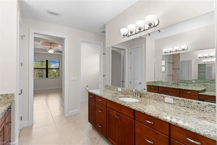 Bathroom with vanity, light tile patterned floors, and ceiling fan