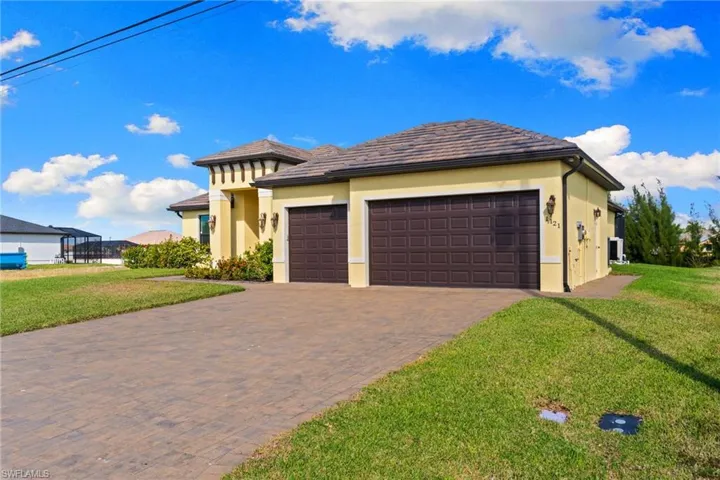 View of front of property with a front lawn, stucco finish, an attached 3-car garage, and decorative driveway
