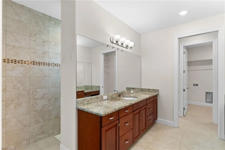 Bathroom featuring vanity, a walk in closet, walk in shower, and recessed lighting