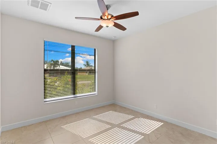 Guest Bedroom with ceiling fan and light tile patterned flooring