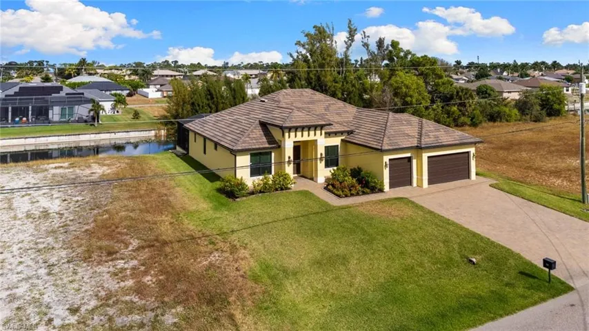 View of front of house, a front yard, a residential view, and paver driveway