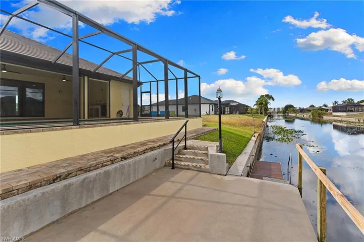 View of patio / terrace enclosure, a water view,  a dock having electric and water, and a canal view