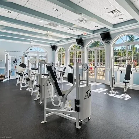 Gym featuring a wealth of natural light, ceiling fan, and french doors