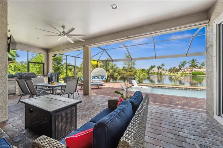 View of patio / terrace with glass enclosure, a water view, and ceiling fan