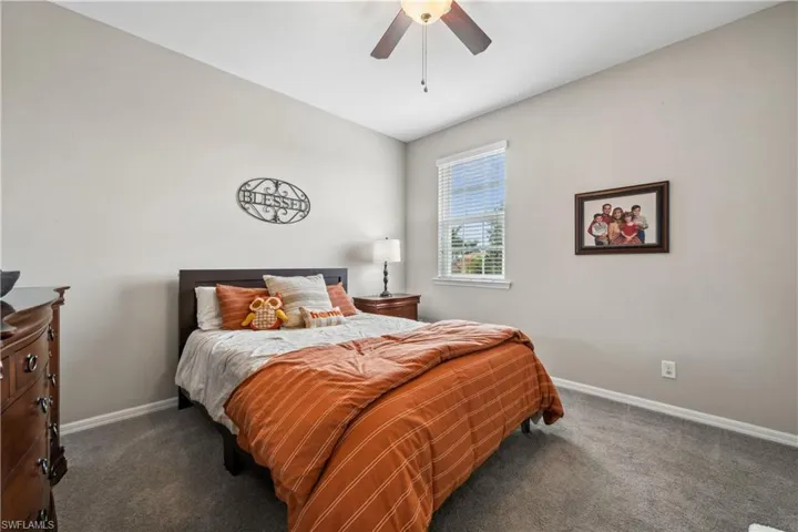 Bedroom with dark carpet and ceiling fan