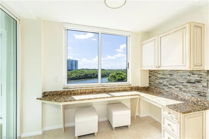 Built in desk, a healthy amount of sunlight, and light tile patterned floors