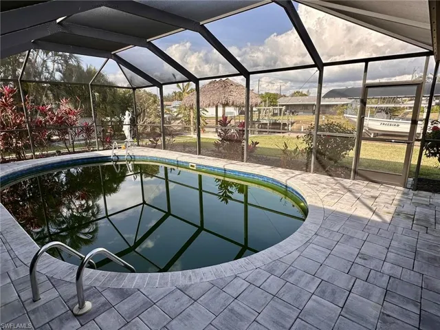 View of swimming pool featuring a lanai and a patio area
