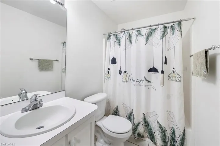 Bathroom featuring a single vanity, integrated sink, and white cabinetry