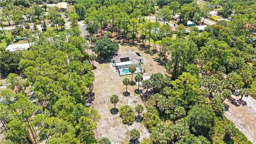 Expansive property featuring a single-story residence with a screened pool enclosure