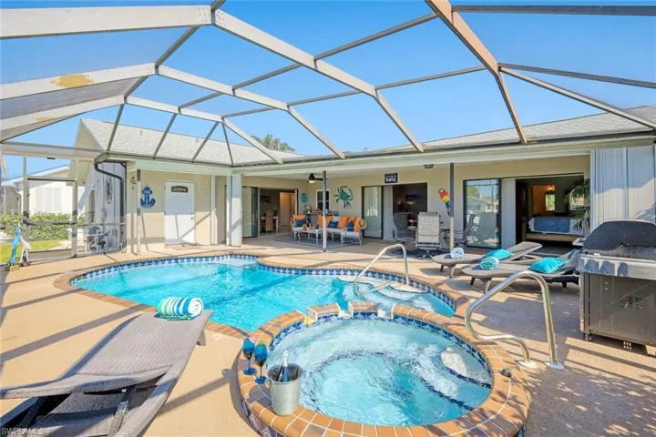 View of South facing electrically heated swimming pool + hot tub
