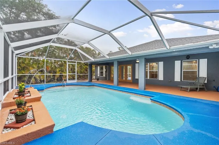 Swimming pool featuring a lanai, a sunroom, and a patio