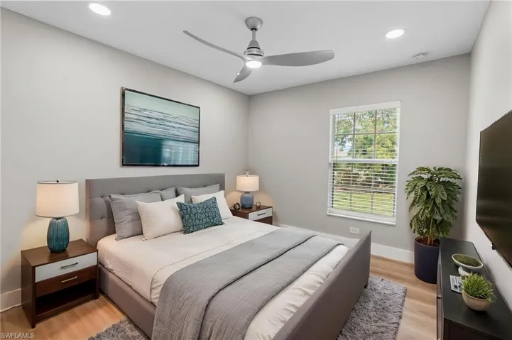 Bedroom with light wood-style floors, ceiling fan, and recessed lighting