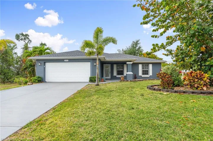 Ranch-style home featuring concrete driveway, a front lawn, an attached garage, stucco siding, and roof with shingles