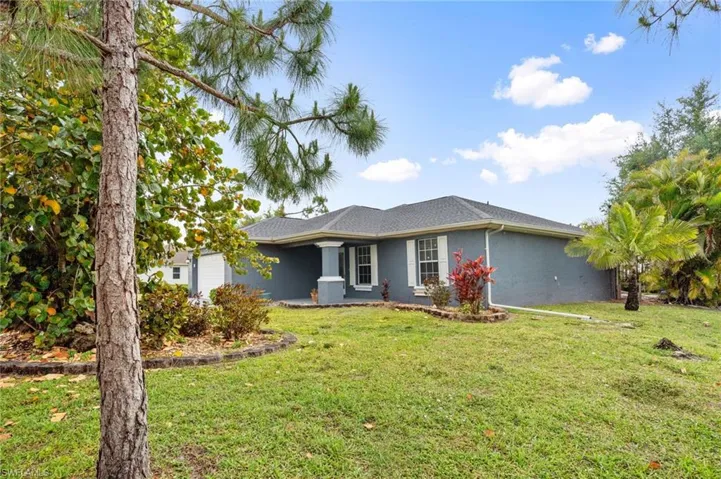 Ranch-style home with a front lawn, stucco siding, and a garage