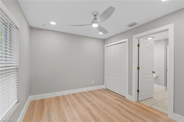 Unfurnished bedroom featuring light wood-style flooring, a closet, ceiling fan, and recessed lighting