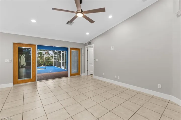 Spare room with a sunroom, vaulted ceiling, a ceiling fan, crown molding, and recessed lighting