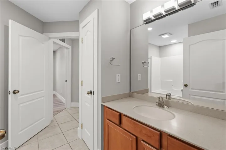 Full bath featuring vanity and light tile patterned floors