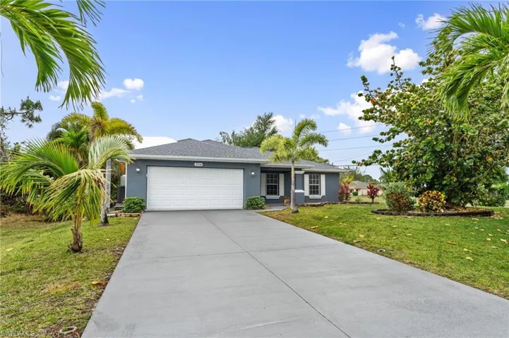 Ranch-style house with a front lawn, a garage, concrete driveway, stucco siding, and a shingled roof