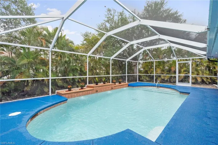 Swimming pool featuring glass enclosure and a sunroom