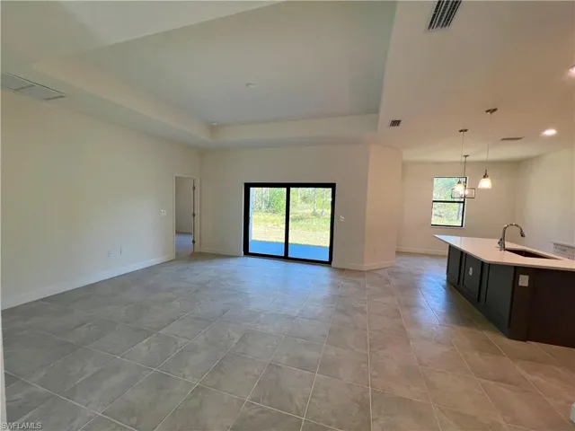 Volume ceilings in living room with tray ceiling and tile floors.
