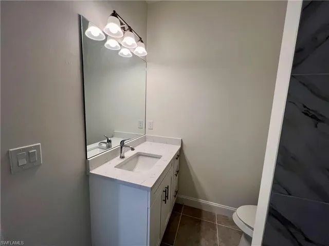 Bathroom with tile patterned floors, vanity, and toilet