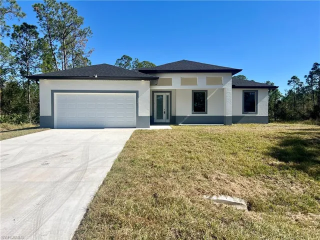 View of front of home featuring a garage and a front lawn
